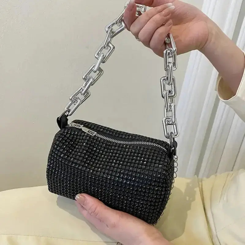 Black allover rhinestone bucket bag with silver chain strap, perfect for prom and versatile occasions.
