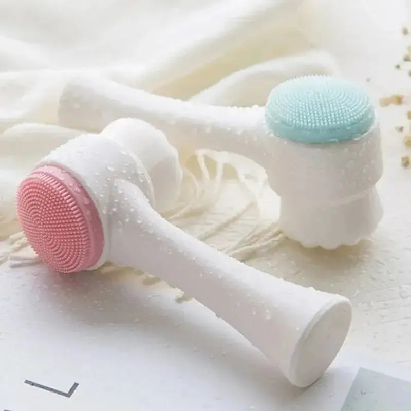Brosse nettoyante pour le visage en silicone 3D, double face, avec couleurs rose et bleu, sur surface mouillée.
