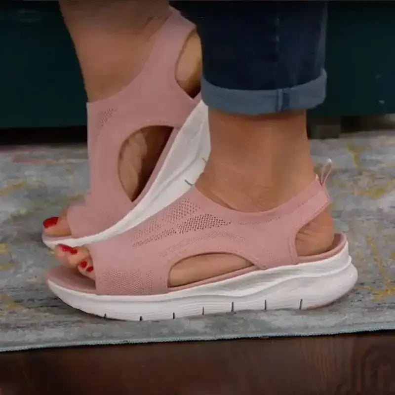 Femme portant des sandales à plateforme en maille roses, style mode, confort décontracté, sur un tapis.