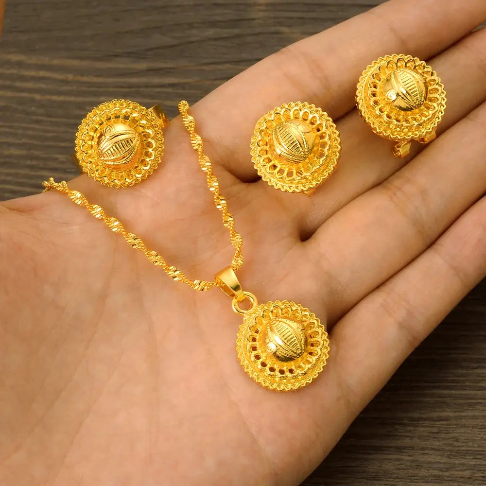 Gold color Ethiopian jewelry set including necklace, earrings, and ring, styled for a bride or festive occasion.