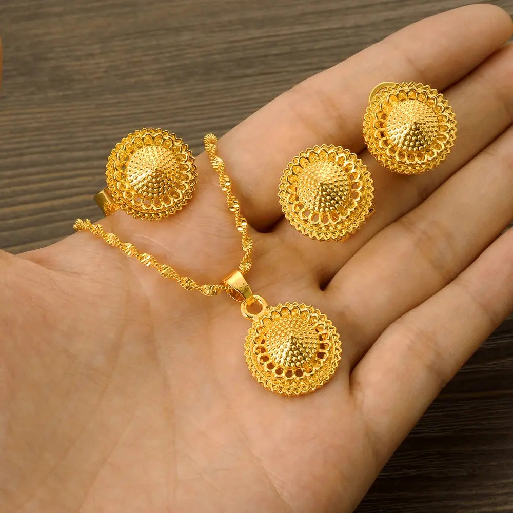 Gold color Ethiopian jewelry set including necklace, earrings, and ring, styled for a bride or festive occasion.