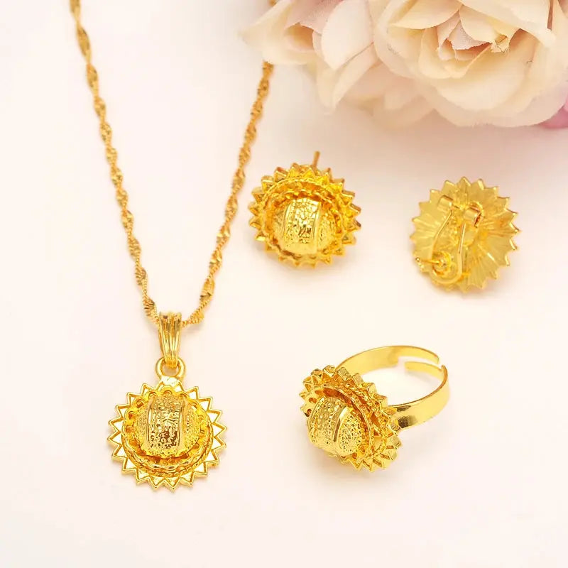 Gold color Ethiopian jewelry set including necklace, earrings, and ring, styled for a bride or festive occasion.