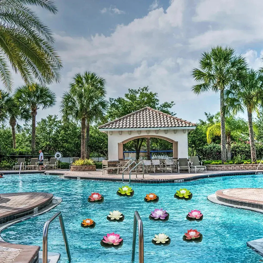 Floating LED lotus lights in a serene pool surrounded by palm trees and a gazebo.