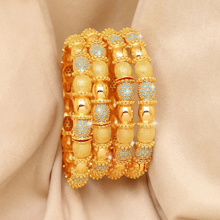 Set of four openable copper bracelets with Middle Eastern design worn on a woman’s wrist.