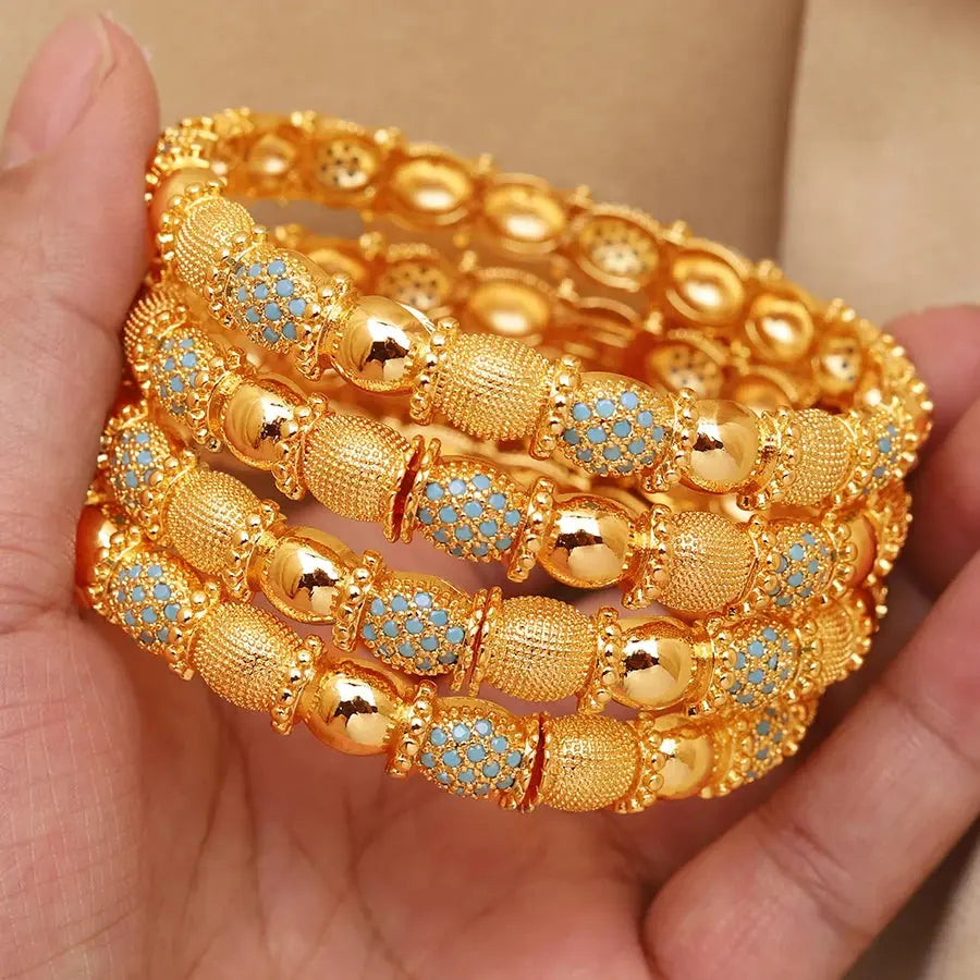 Set of four openable copper bracelets with Middle Eastern design worn on a woman’s wrist.