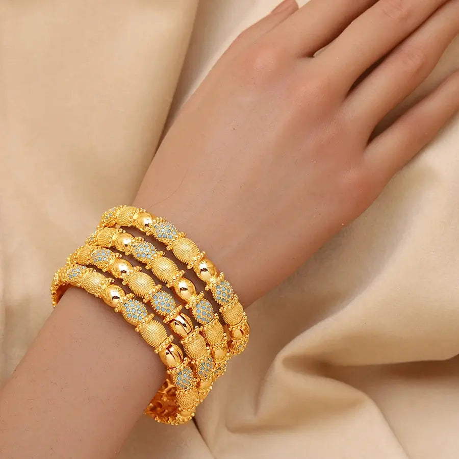 Set of four openable copper bracelets with Middle Eastern design worn on a woman’s wrist.