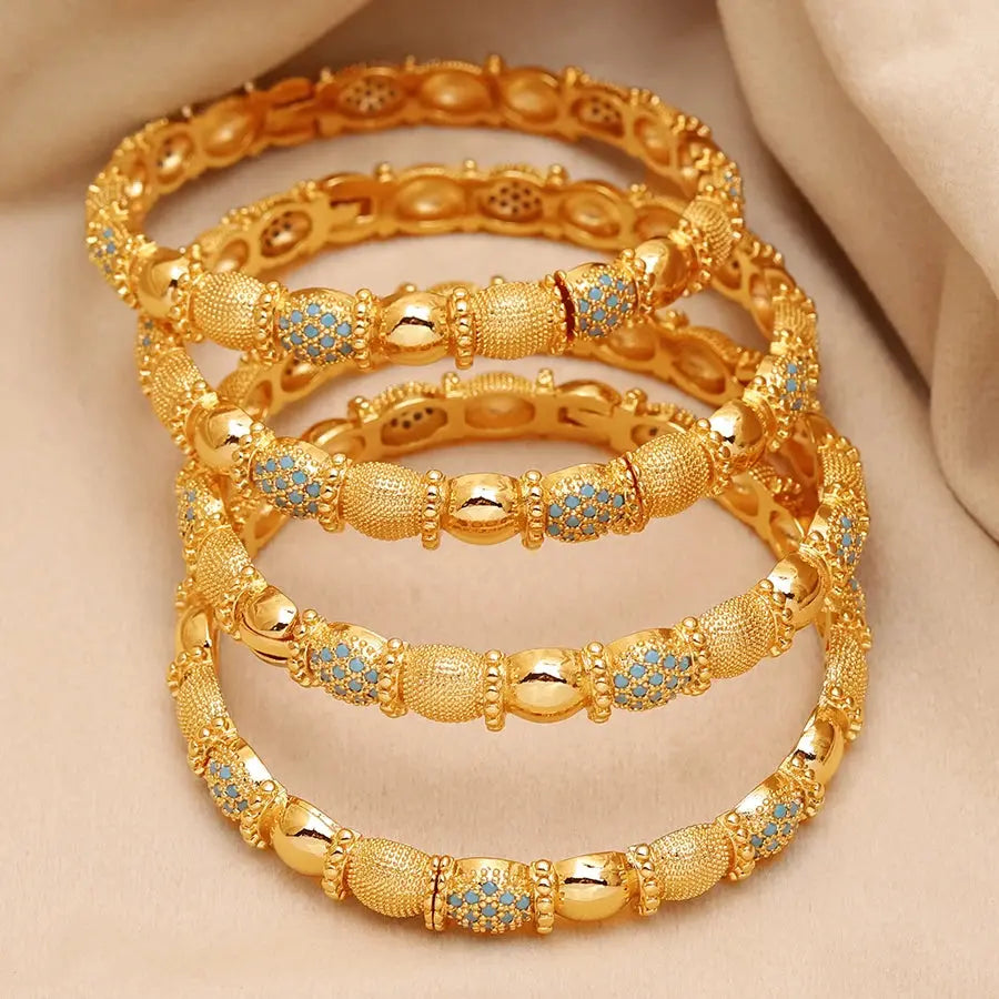 Set of four openable copper bracelets with Middle Eastern design worn on a woman’s wrist.