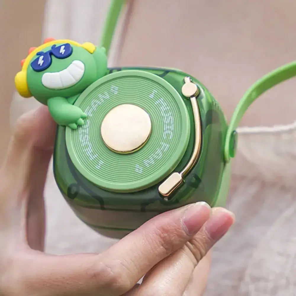 Portable green fan with a playful character on top, designed for fun and functionality, perfect for keeping cool.