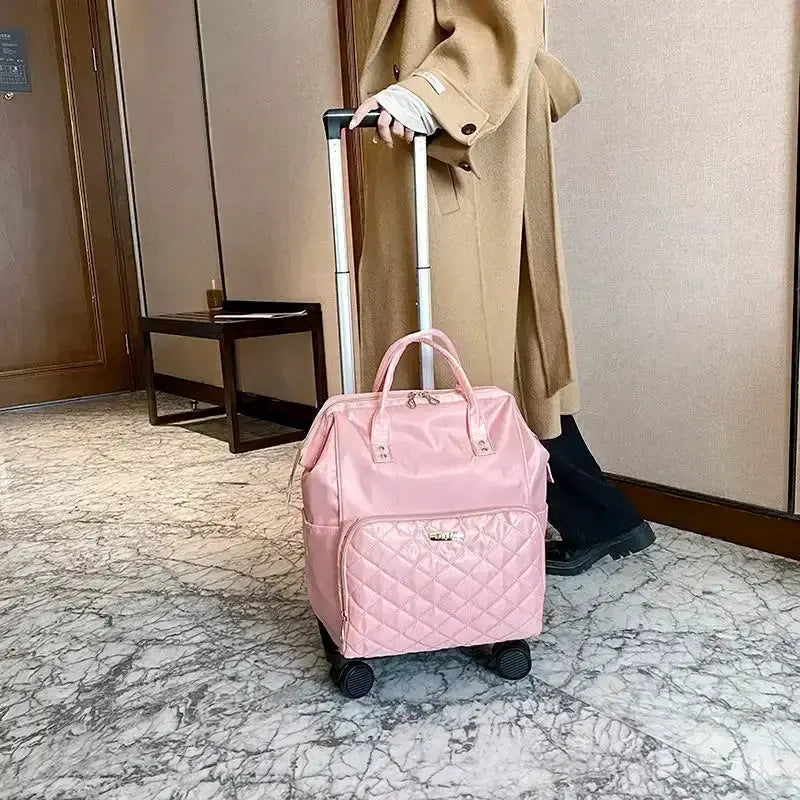 Stylish pink portable travel bag with wheels, perfect for carry-on luggage, seen in a modern hotel setting.