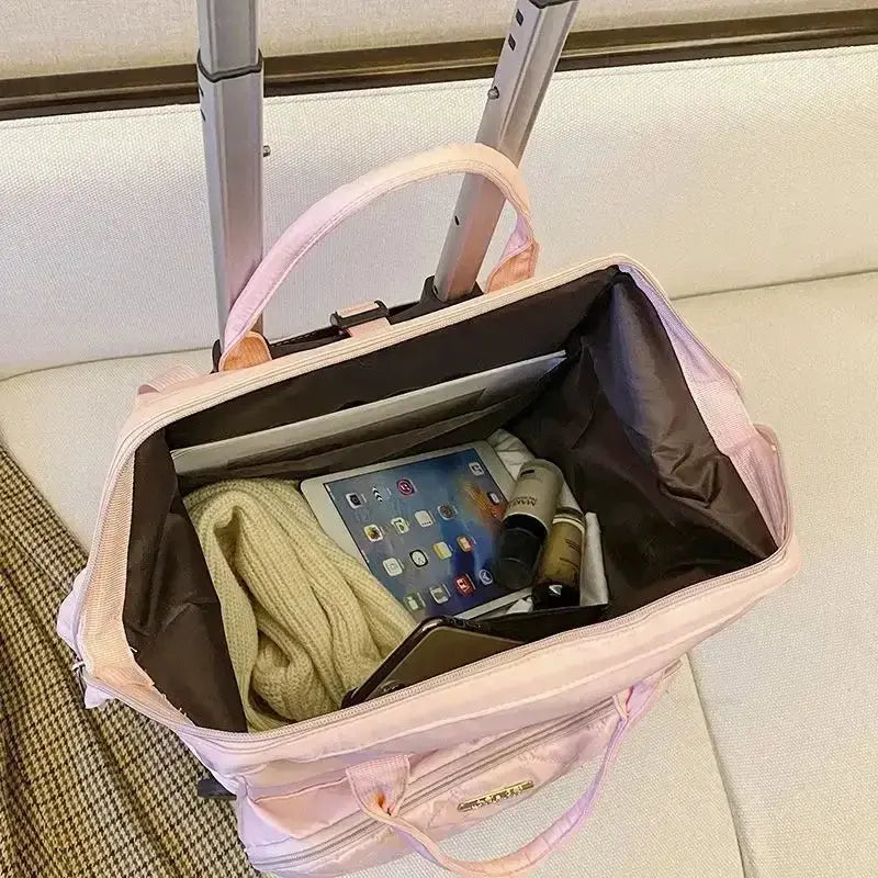 Stylish pink portable travel bag with a spacious interior, holding an iPad and personal items.