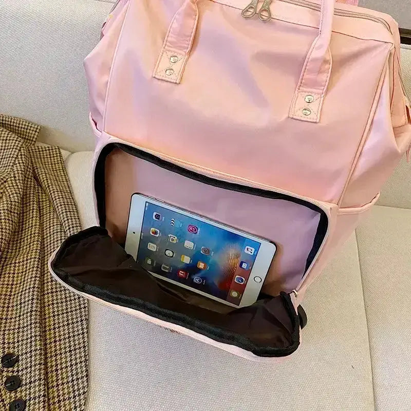 Stylish pink portable travel bag with tablet compartment and spacious interior for travel essentials.