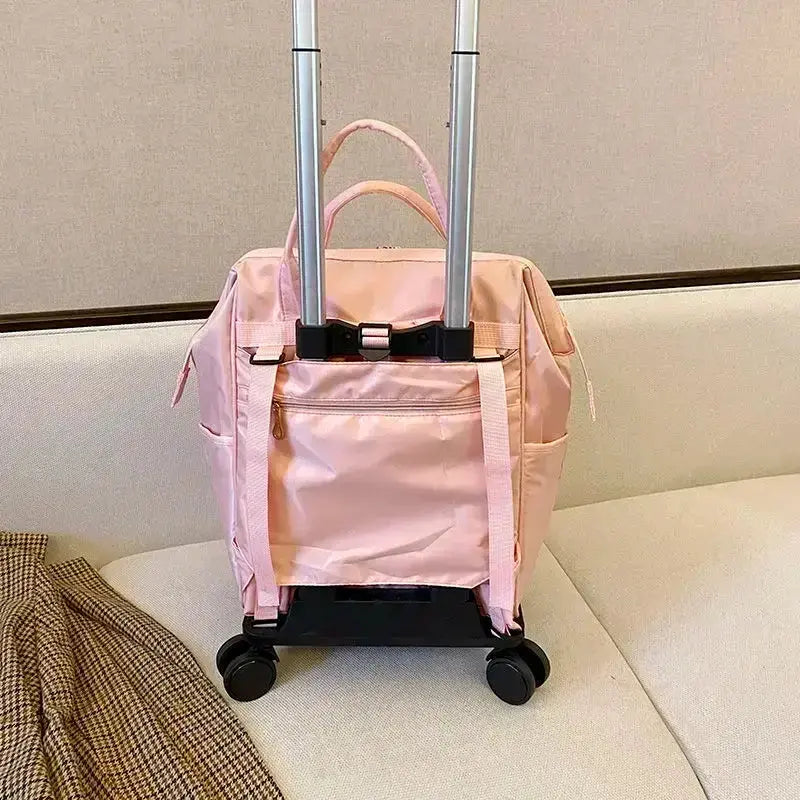 Stylish pink portable travel bag with wheels and dual handles on a sofa.