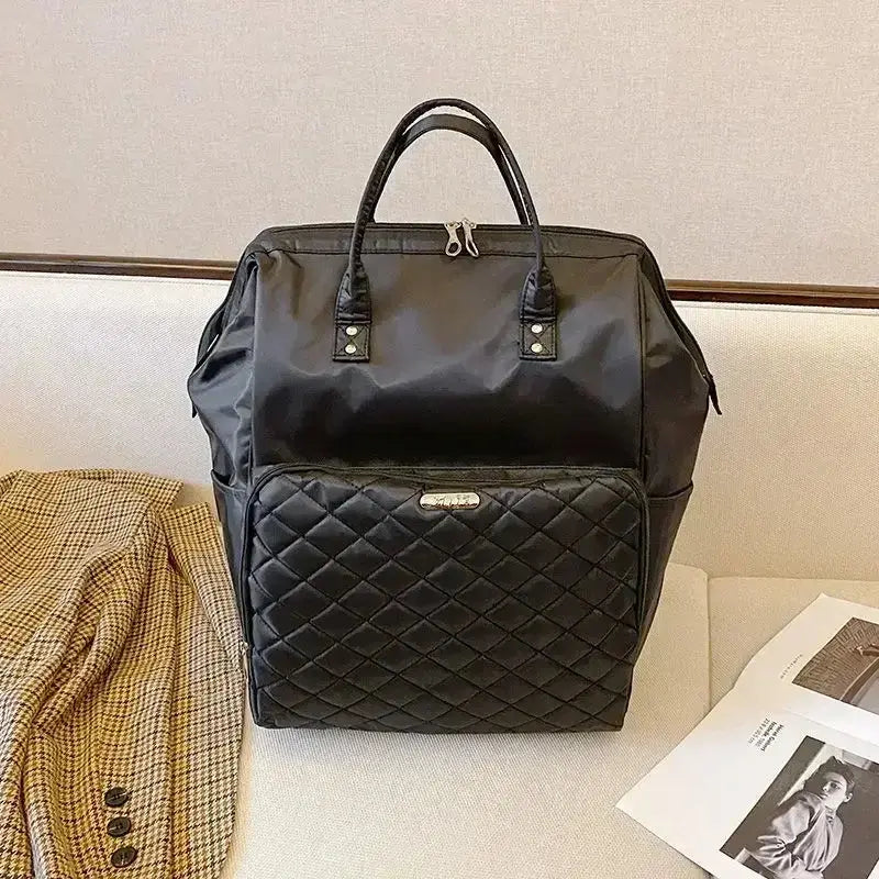 Large capacity black designer travel bag with quilted front pocket, stylish and waterproof, ideal for carry-on.