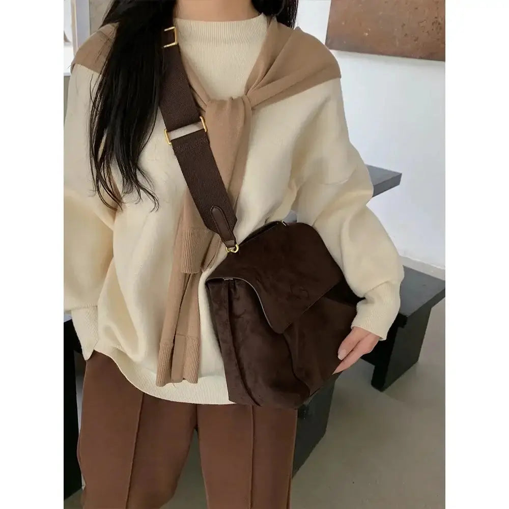 Femme portant un sac à bandoulière en cuir givré, vêtue d&