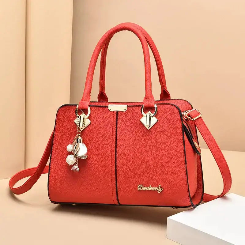 Nouveau sac à bandoulière pour femme en cuir rouge, grande capacité avec accessoires décoratifs.