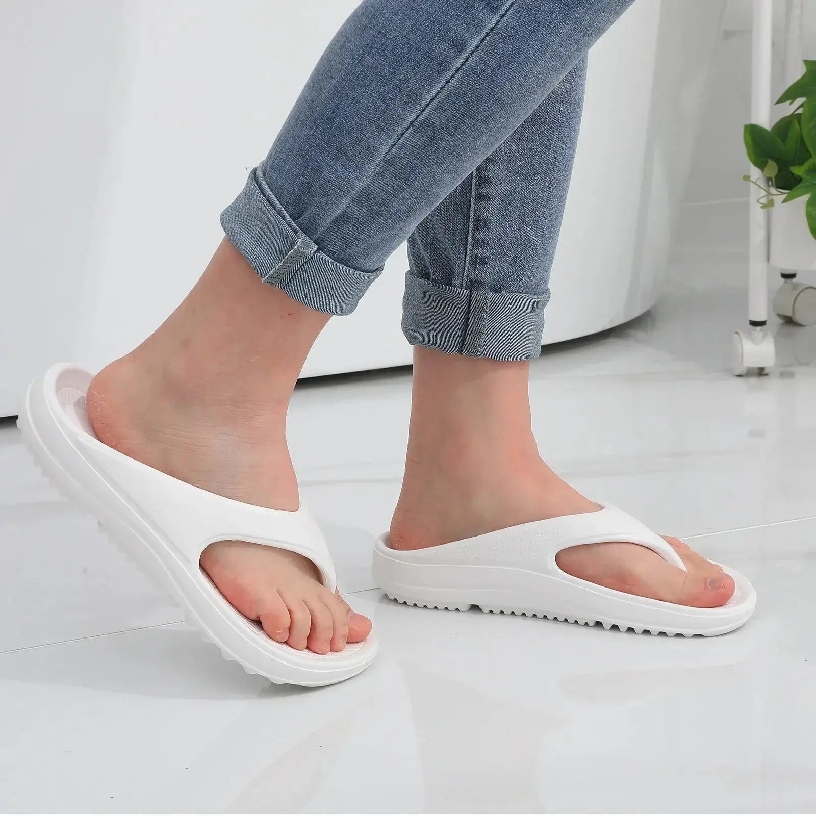 Femme portant des sandales orthopédiques blanches modernes, avec jean, style décontracté.