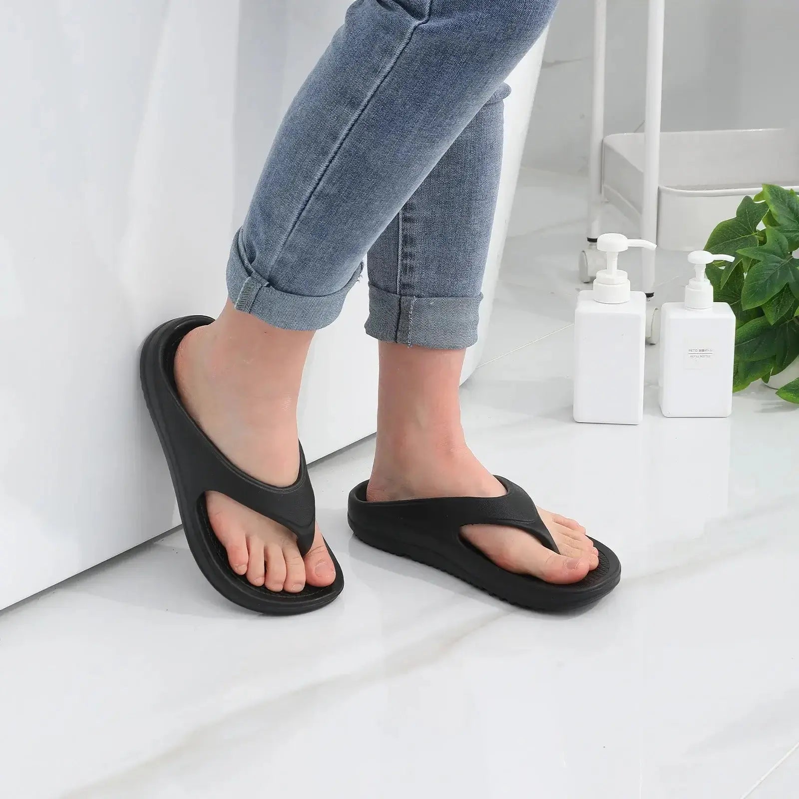 Femme portant des sandales orthopédiques modernes noires, confortables, avec un design ouvert et semelle en EVA.