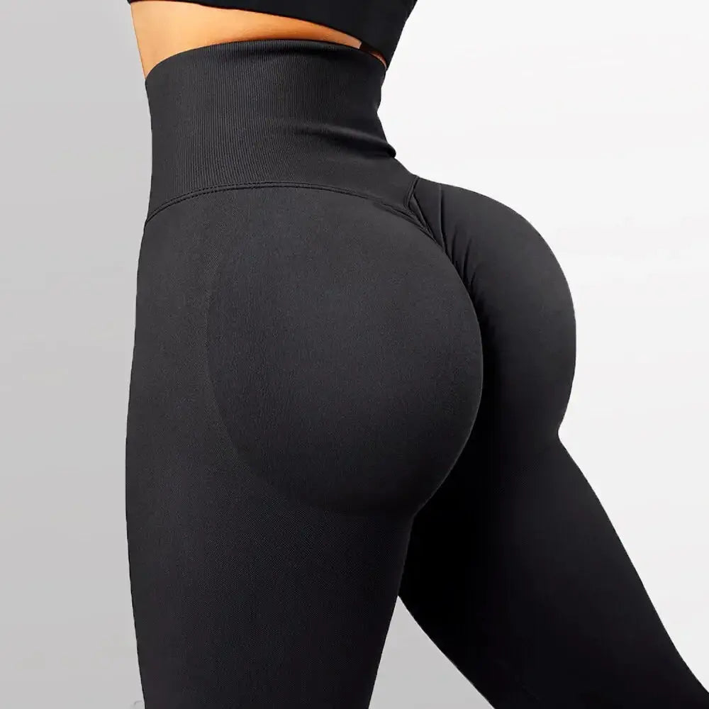 High-waisted seamless knitted leggings worn by a woman during a fitness workout, showing a peach-lift design and nude color finish.