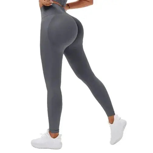 High-waisted seamless knitted leggings worn by a woman during a fitness workout, showing a peach-lift design and nude color finish.