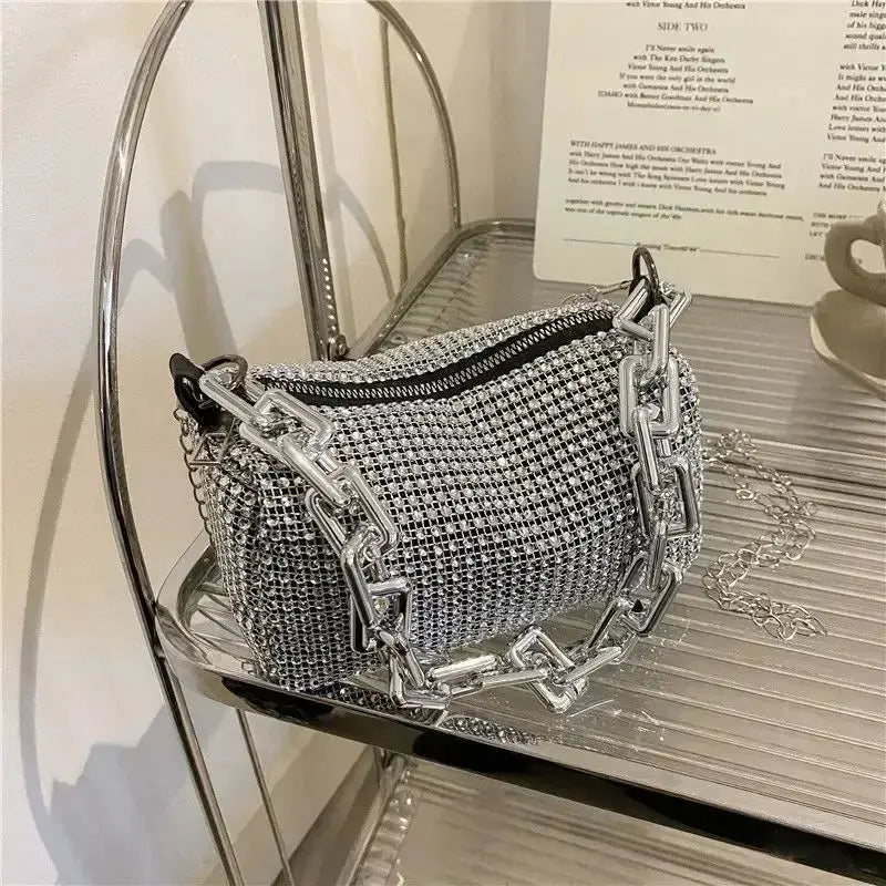 Allover rhinestone bucket bag with glitter chain on a metallic shelf, perfect for women and versatile occasions.