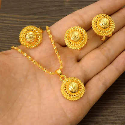 Gold color Ethiopian jewelry set including necklace, earrings, and ring, styled for a bride or festive occasion.