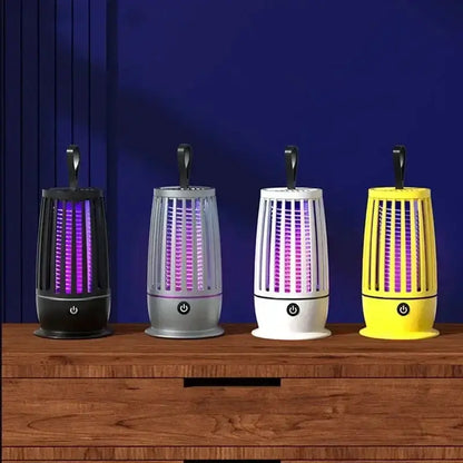 Lampe anti-moustiques UV Xiomi en noir, gris, blanc et jaune sur une table en bois avec fond mural violet.