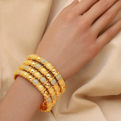 Set of four openable copper bracelets with Middle Eastern design worn on a woman’s wrist.
